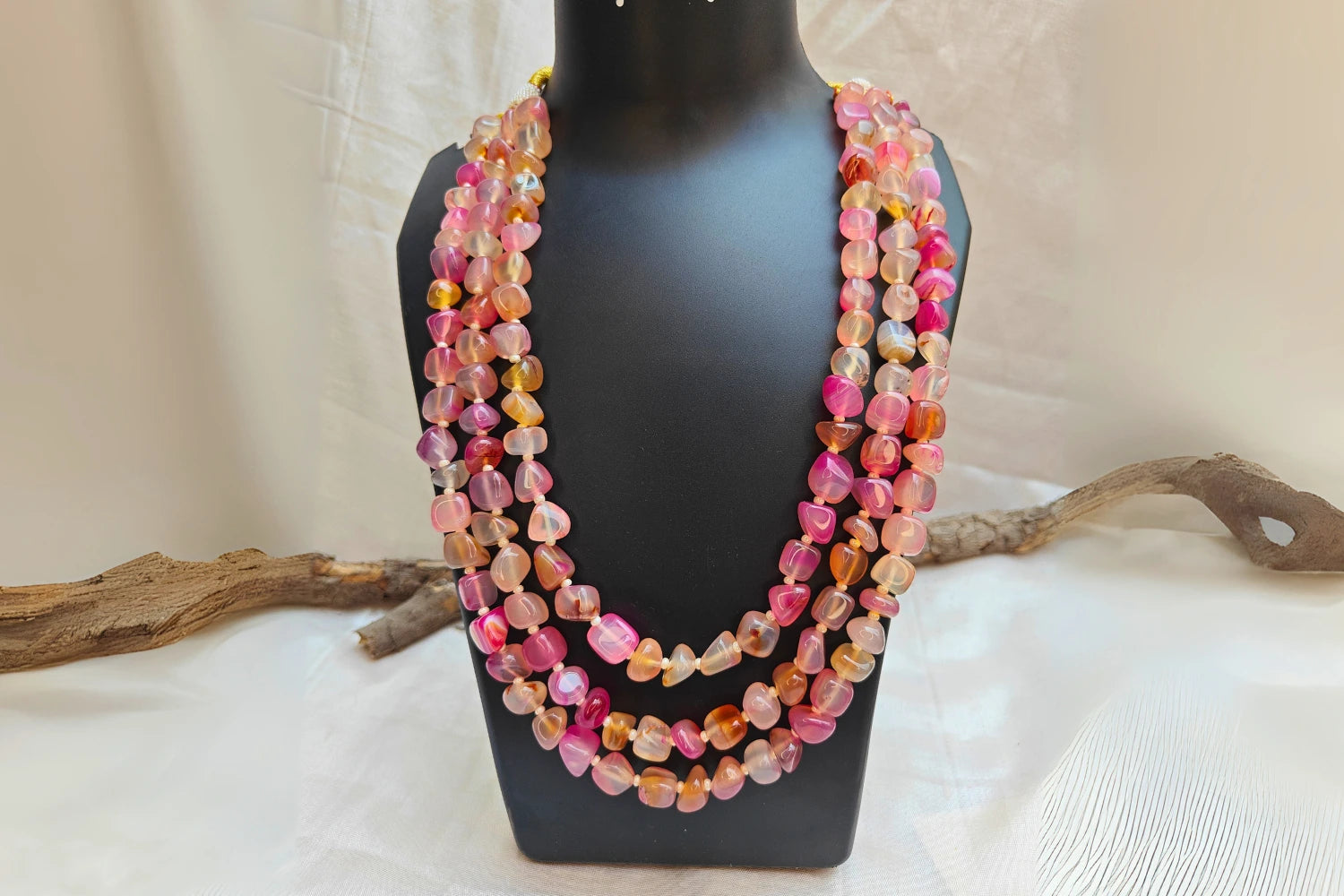 Bead Mala showcasing light pink rose quartz stones, perfect for love and harmony, displayed elegantly on a jewelry stand.